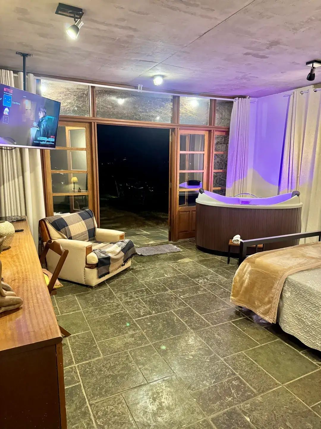 Quarto do Refúgio Céu Azul com cama de casal e ofurô com cromoterapia ao lado