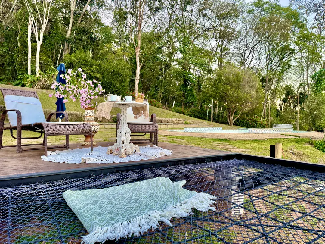 Mesa decorada ao ar livre no Refúgio Céu Azul, com a serra de Itaipava ao fundo