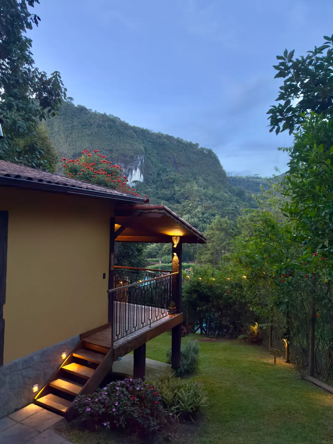 Escada de acesso ao Chalé Lua Nova iluminada ao entardecer, com a serra ao fundo