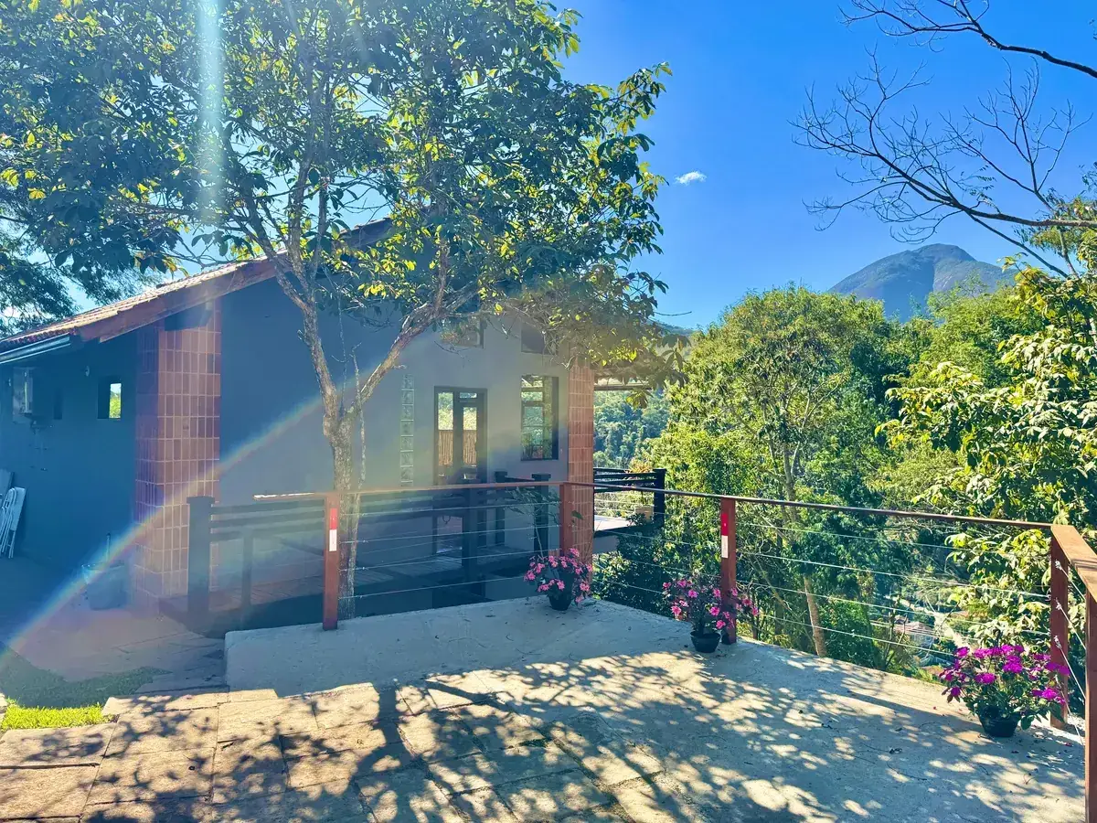 Fachada da Cabana Orion em tijolo aparente e branco, entre as árvores do Vale do Santa Mônica