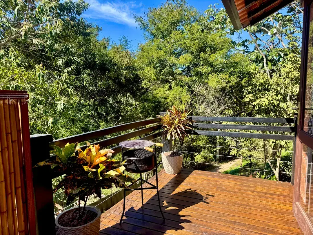 Deck da Cabana Orion com churrasqueira e vista para a mata