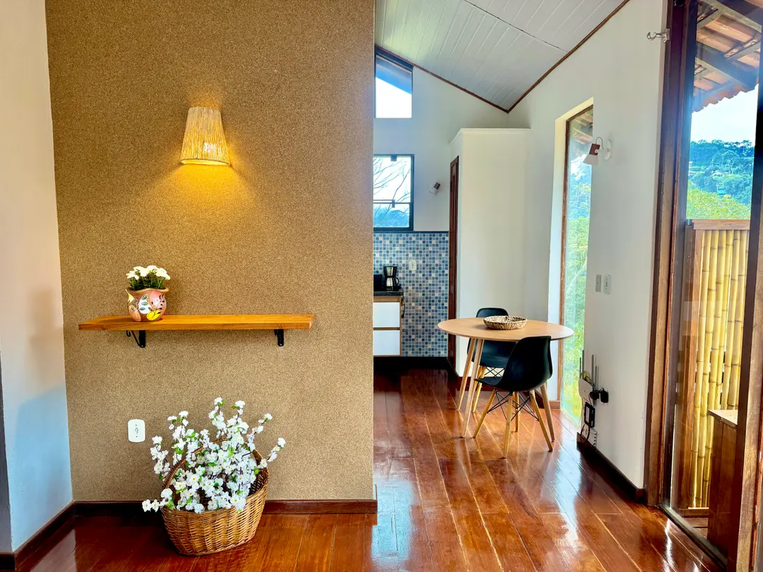 Cozinha integrada à sala da Cabana Orion, com prateleira de madeira e luminária