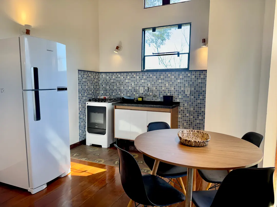 Fogão e mesa de jantar redonda da Cabana Orion, com revestimento azul na parede