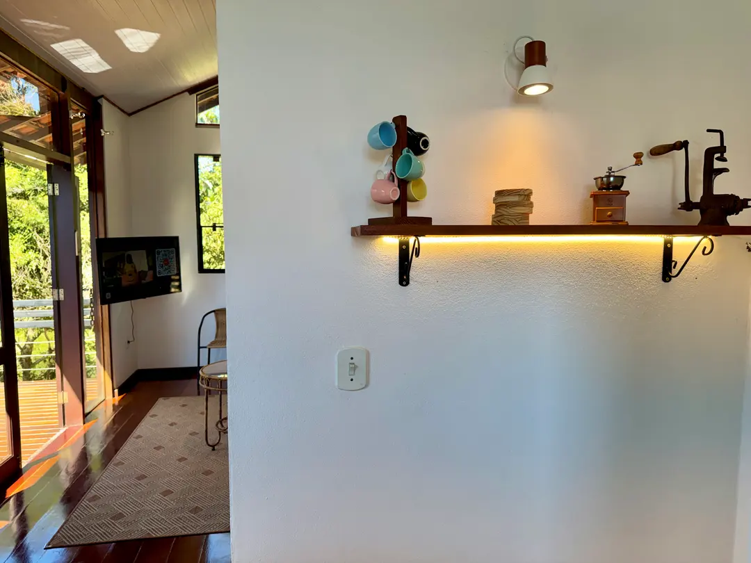 Prateleira de madeira da Cabana Orion com moedor de café e objetos decorativos