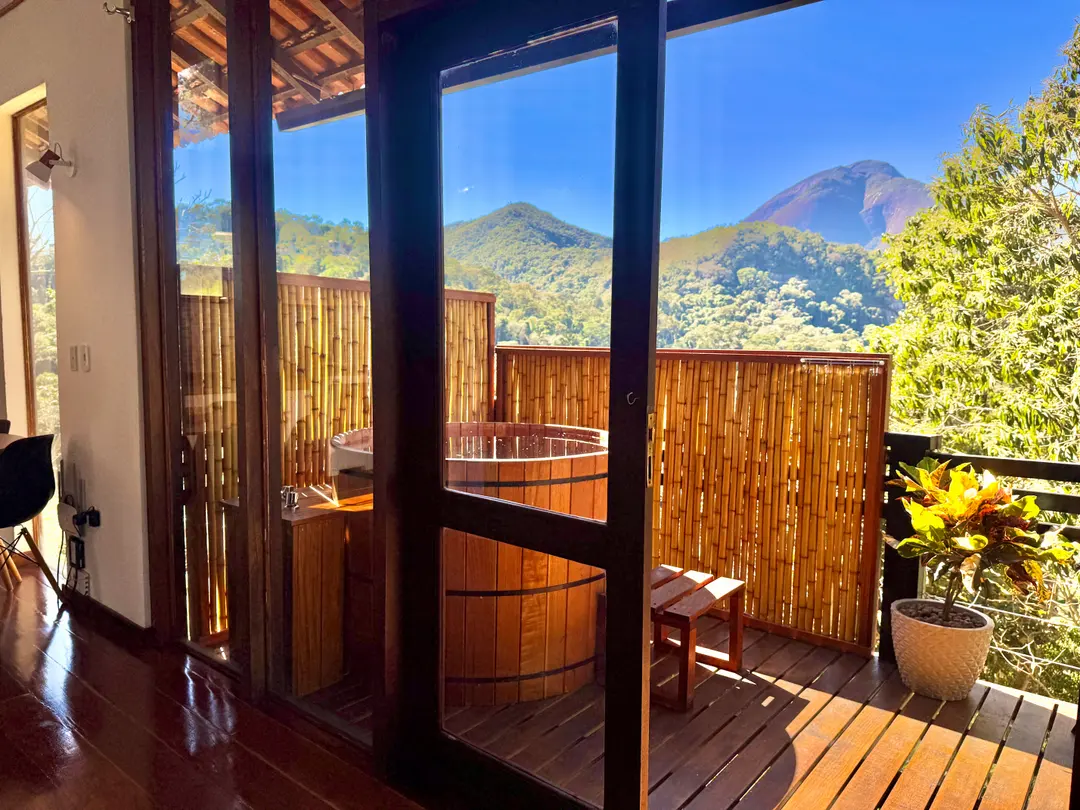 Deck da Cabana Orion com o ofurô e vista aberta para as montanhas de Itaipava