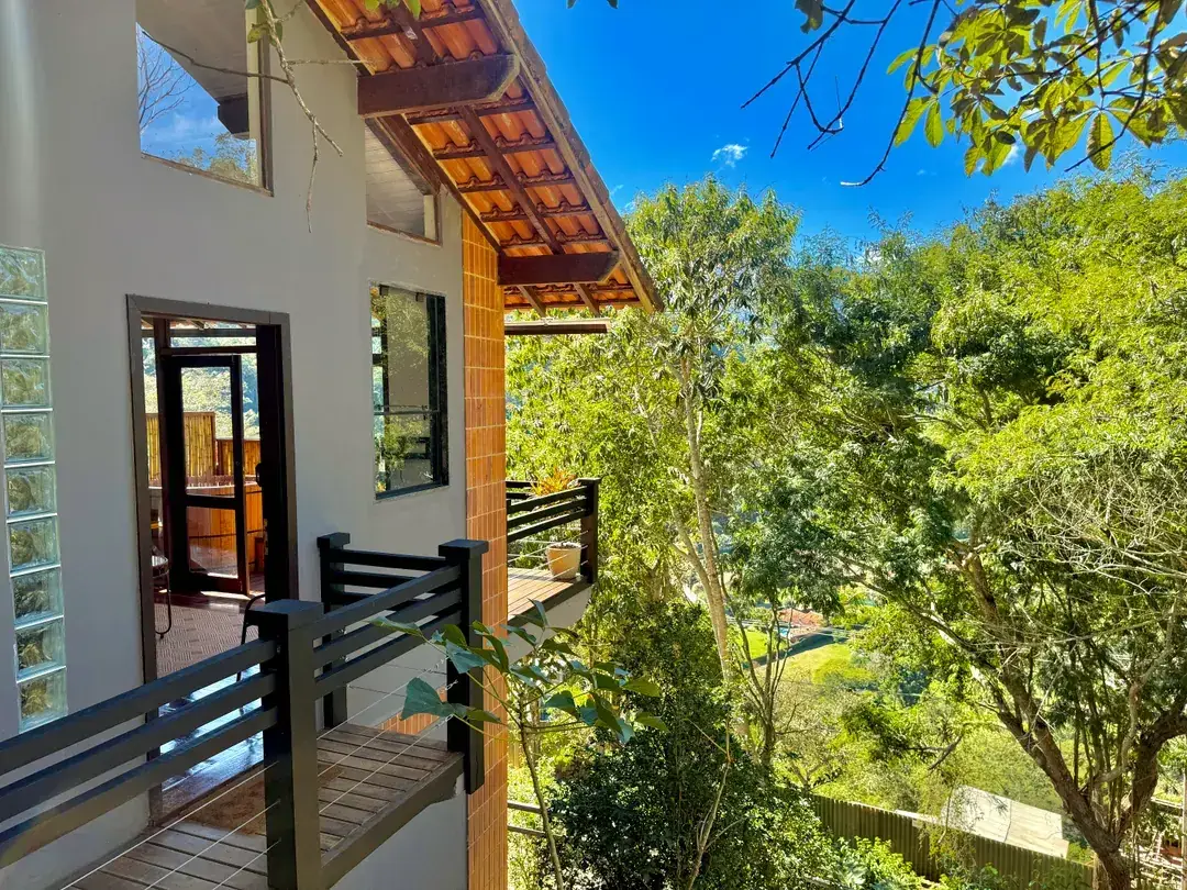 Fachada de dois andares da Cabana Orion, discreta entre as árvores do Vale do Santa Mônica