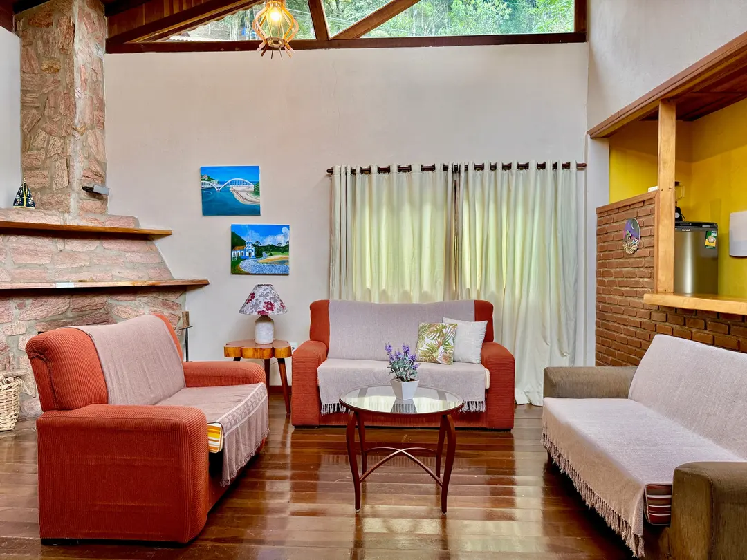 Sala de estar do Studio com sofás, quadros e lareira ao fundo