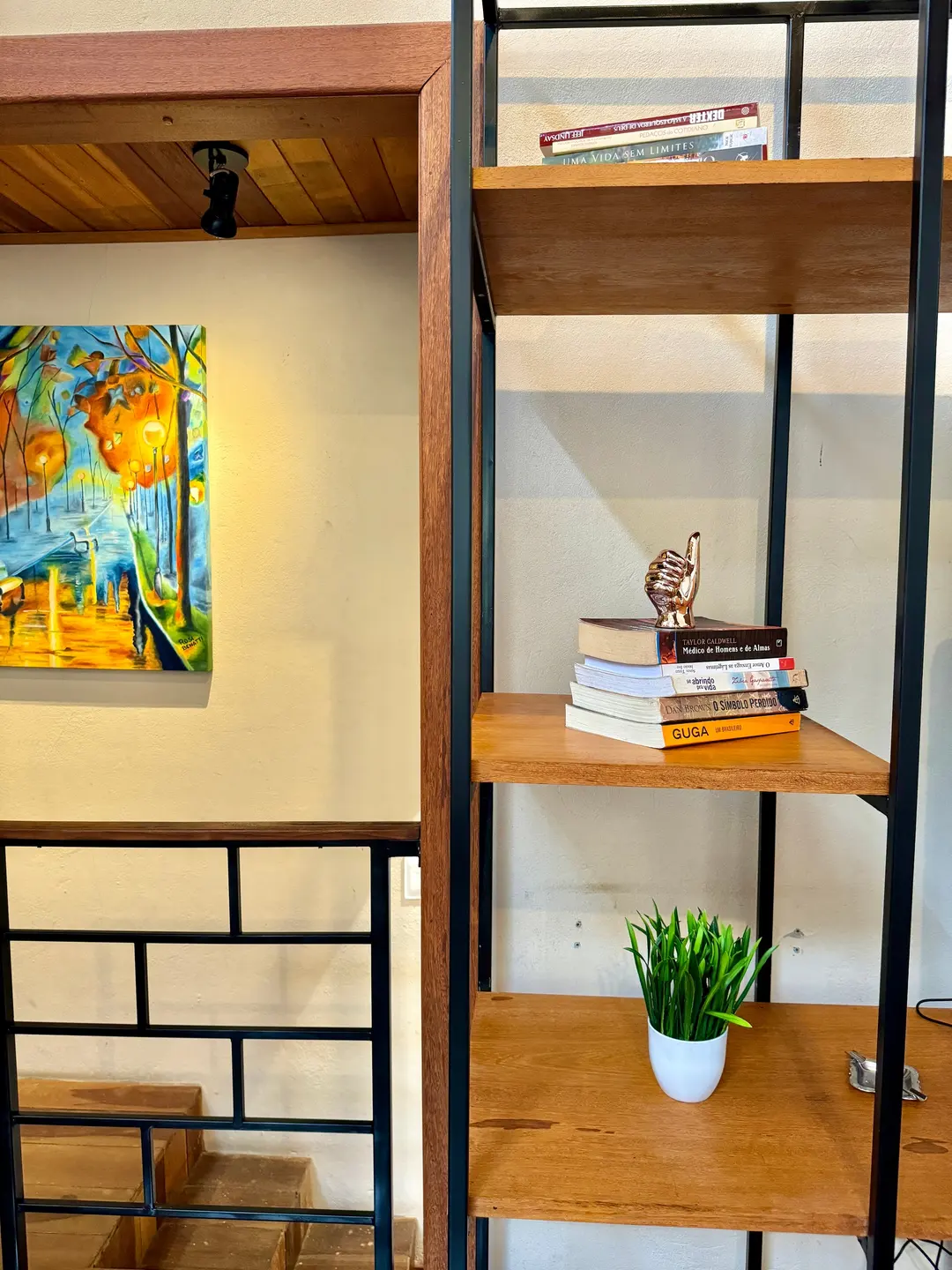 Estante de madeira com livros e quadro decorativo